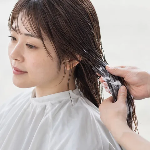 トリートメントを髪になじませる手元のイメージ