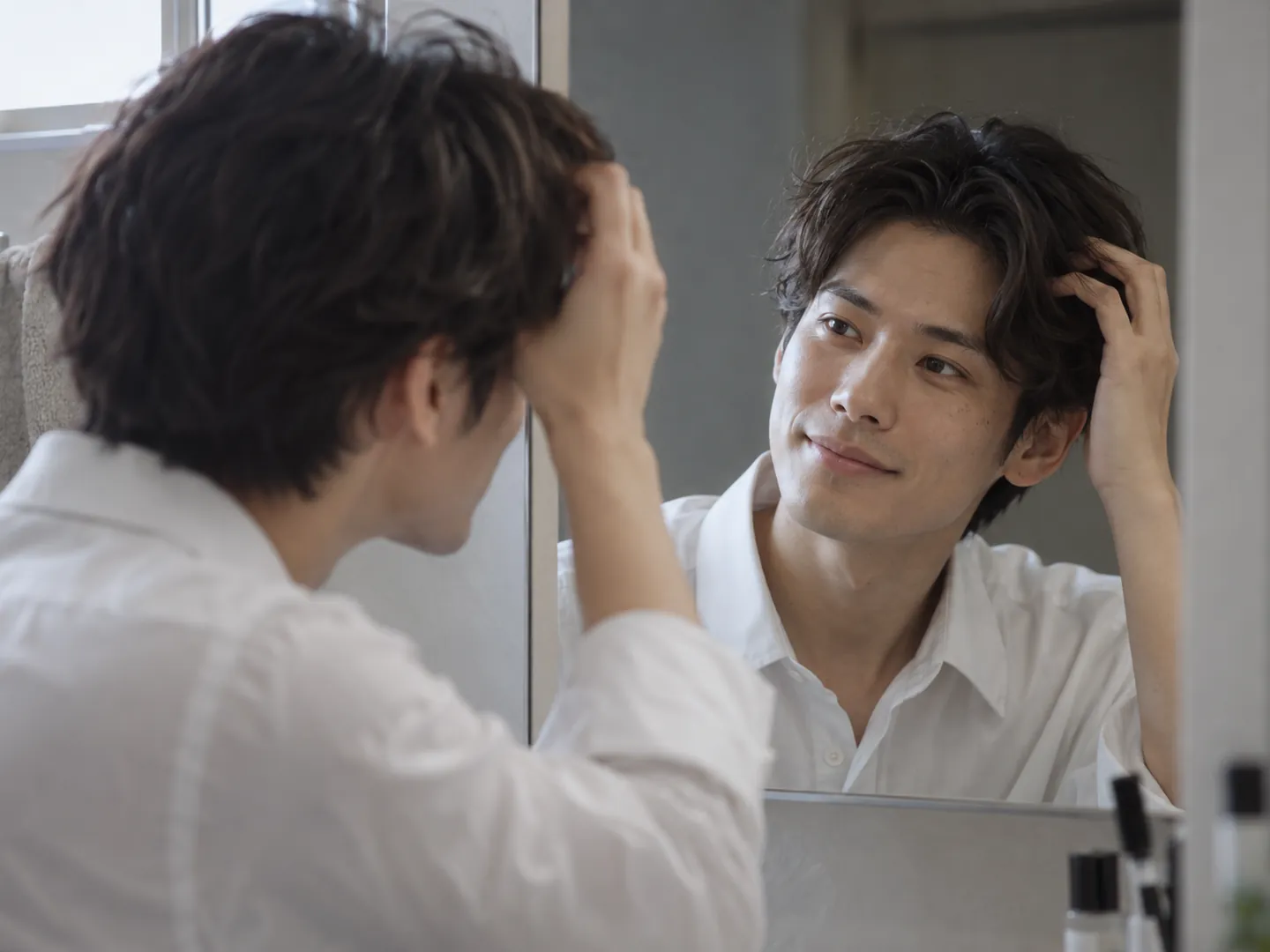 朝、乾かした髪を手ぐしで整える男性のイメージ